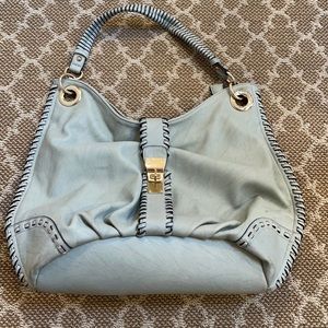 Beautiful gray shoulder bag with zipper and lock closures.